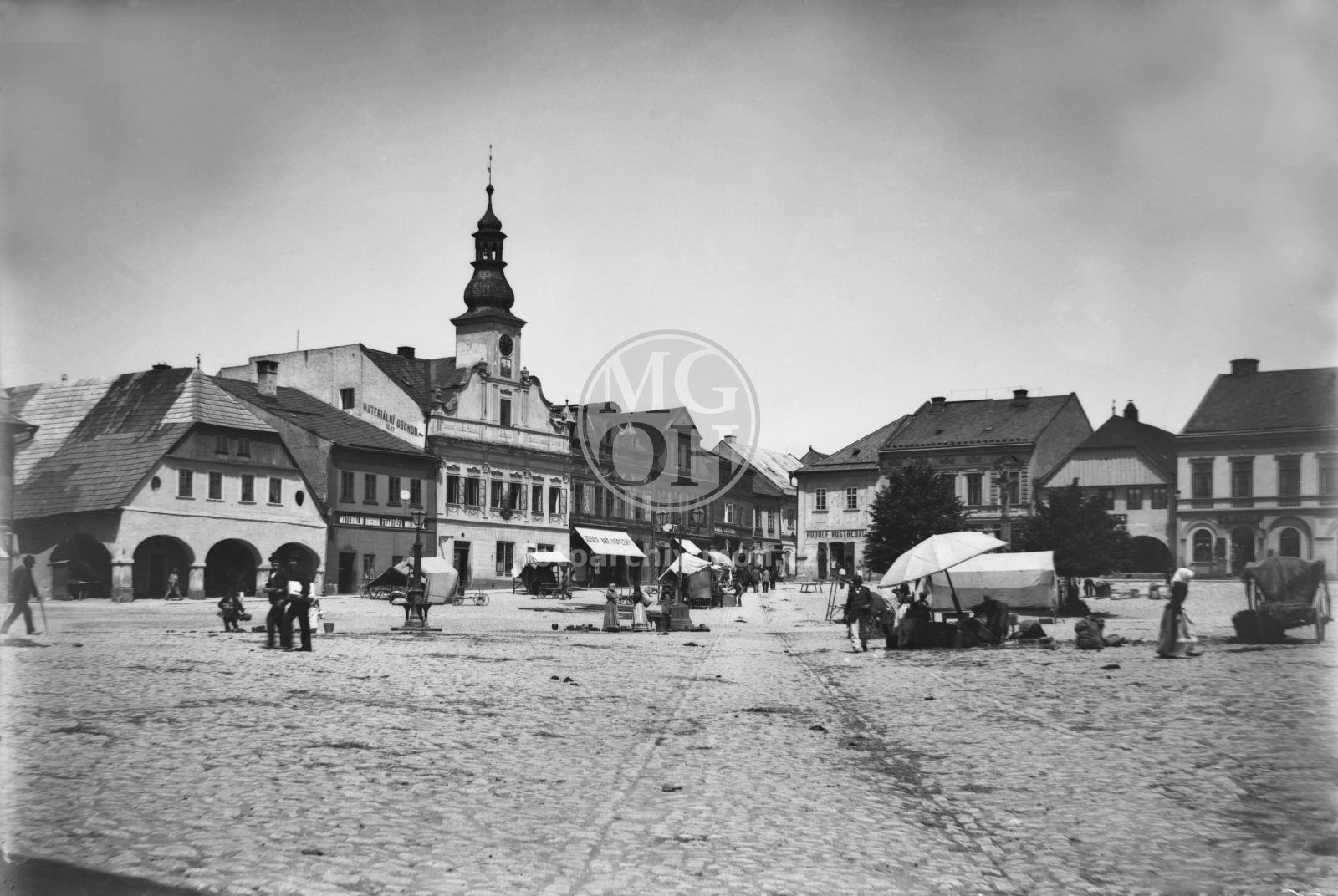 Negativ - Staré náměstí - trh (čp. 66, čp. 67 (Materiální obchod Fr. Holoubek), čp. 68, čp. 69 (Josef Ant. Kopecký), čp. 70, čp. 71 (Karel Lederer), čp. 25 (Rudolf Vostřebal), čp. 26. čp. 27, čp. 28/29)
Snímek byl pořízen po roce 1896, kdy byly místo kaše