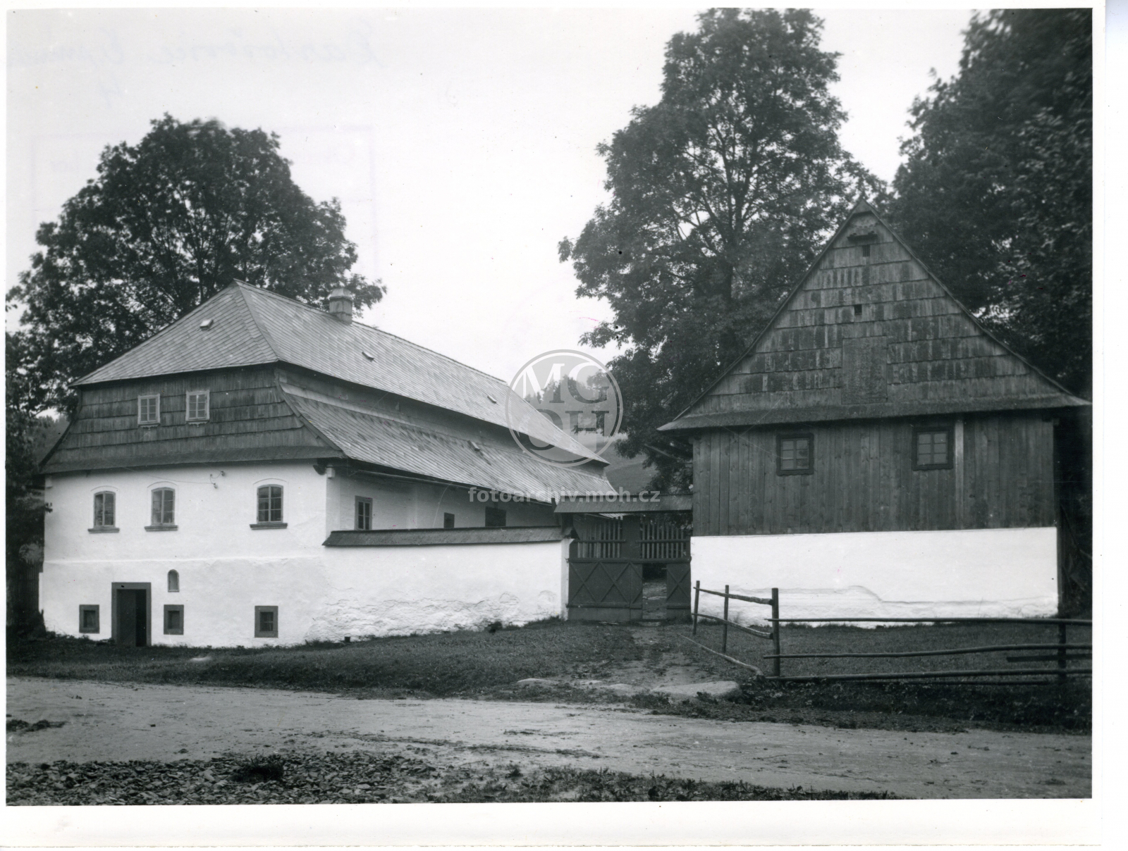 Fotografie - Lidová stavba. Selská usedlost s obestavěným dvorem.Obytná budova patrová zděná, kryt eternit, na štítu šindel.(Mansardová polovalba) Vrata tesařsky zdobená.
