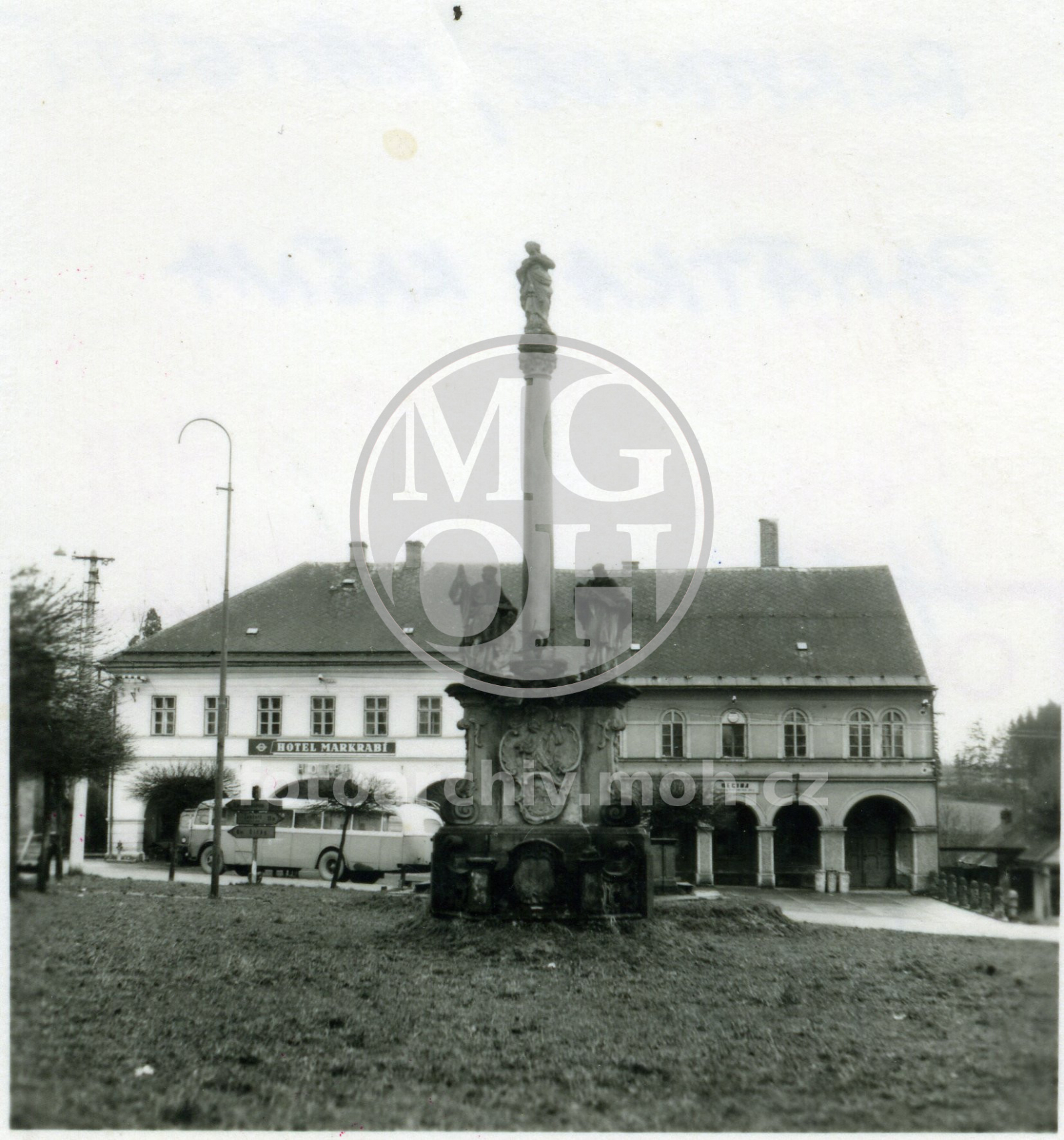Fotografie - Pohled na kašnu uprostřed náměstí (spíš jde o mariánský sloup, kašna je schovaná za ním)