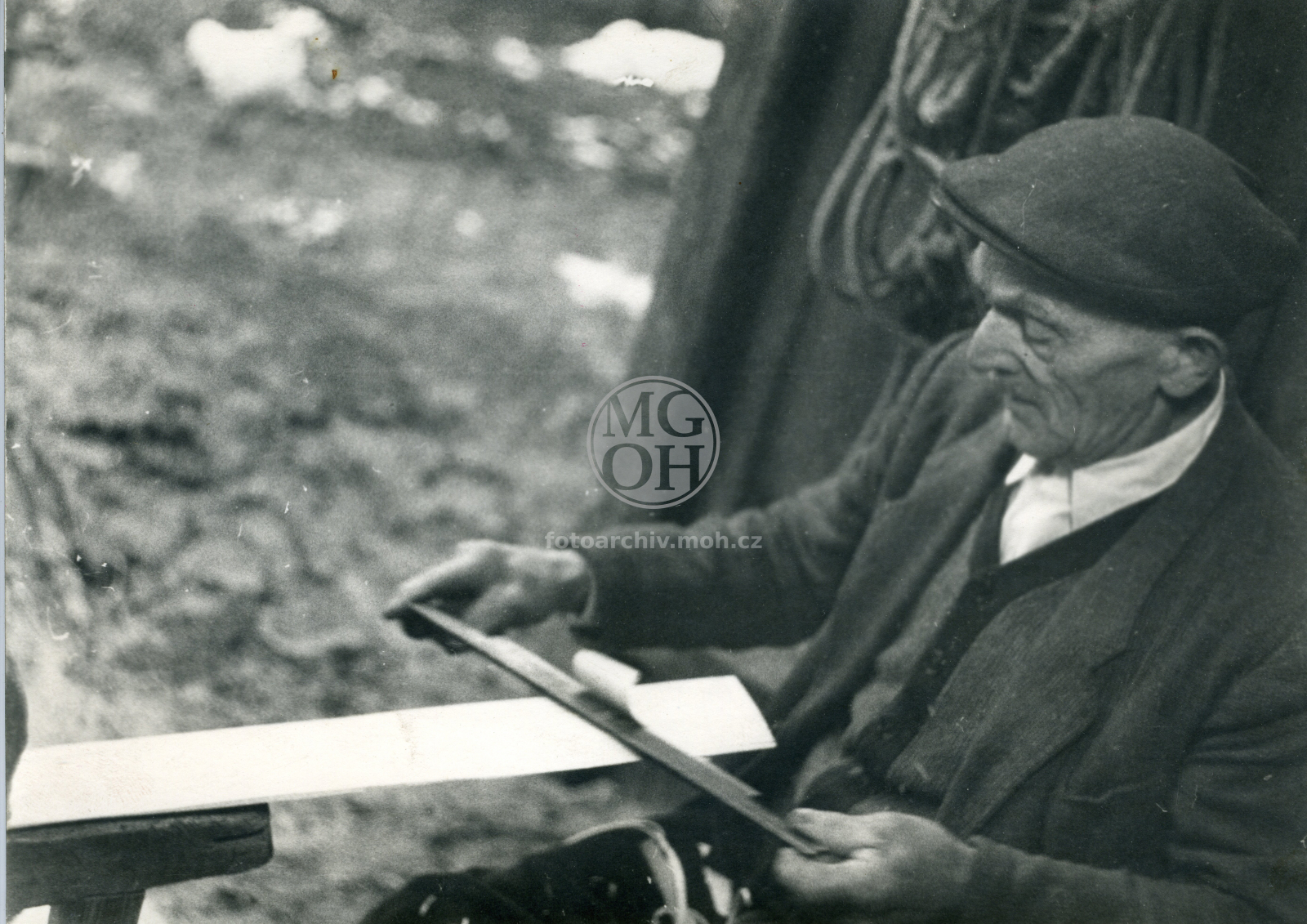 Fotografie - Šindelář při práci, hoblování šindele pořízem