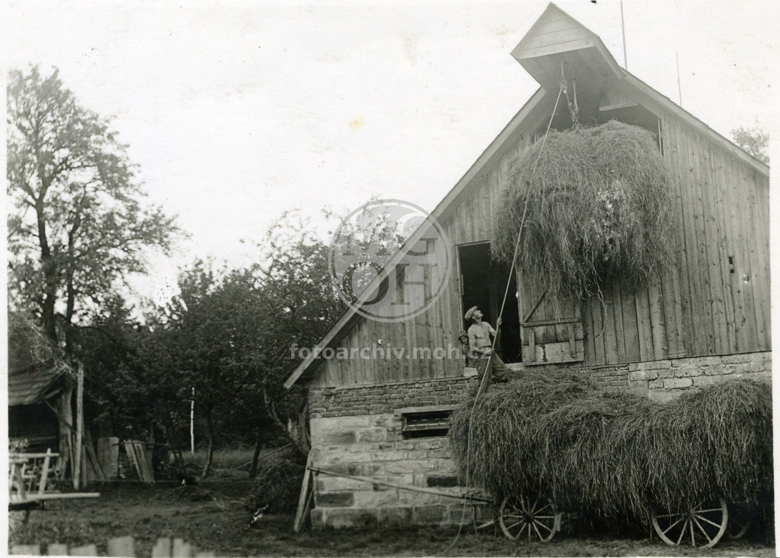 Fotografie - Zvedání fundele s fůry jednokoňským potahem - moment vjezdu na půdu