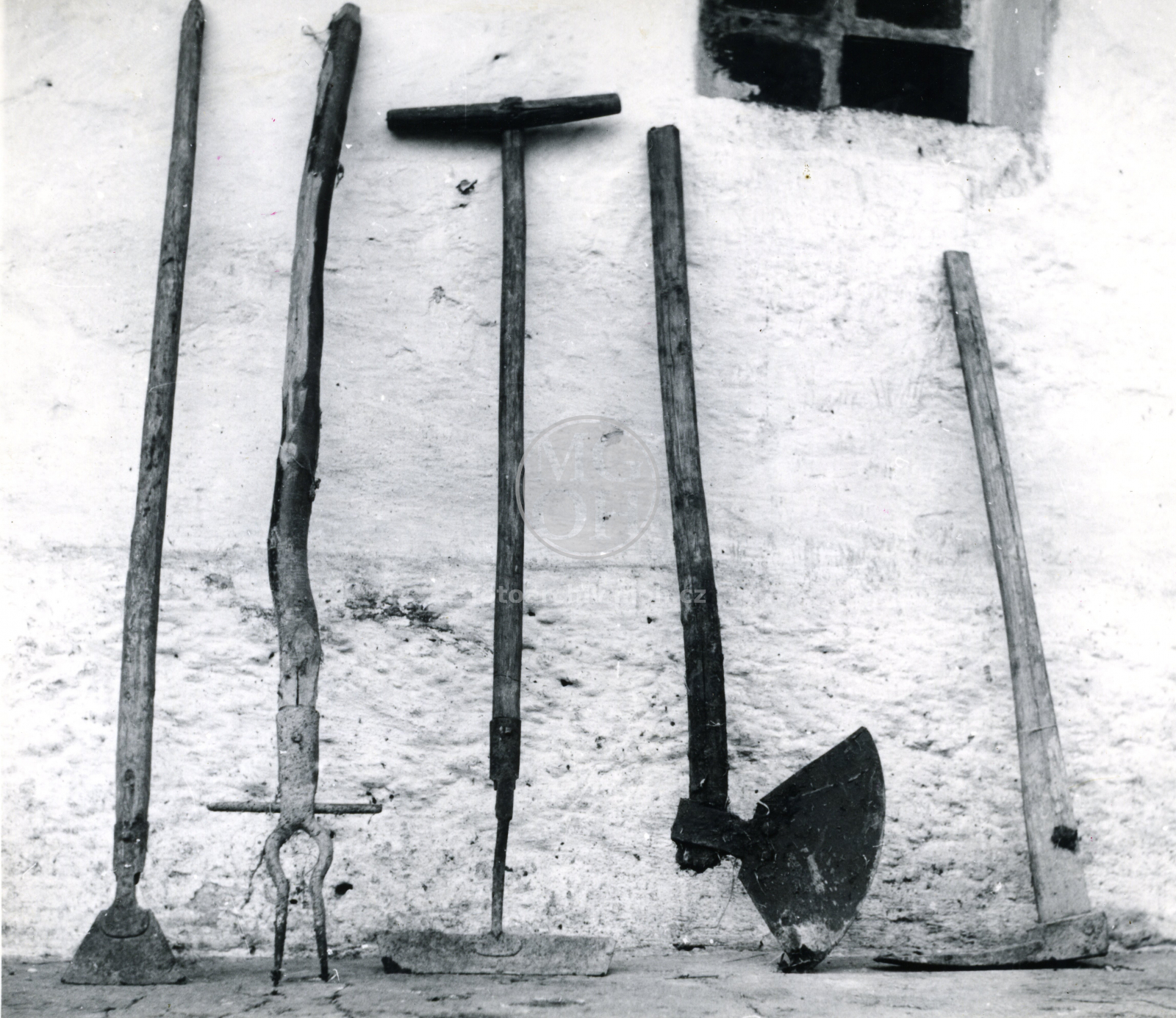 Fotografie - nástroje při práci na poli - šintek na řepu, sekera na hnůj atd.