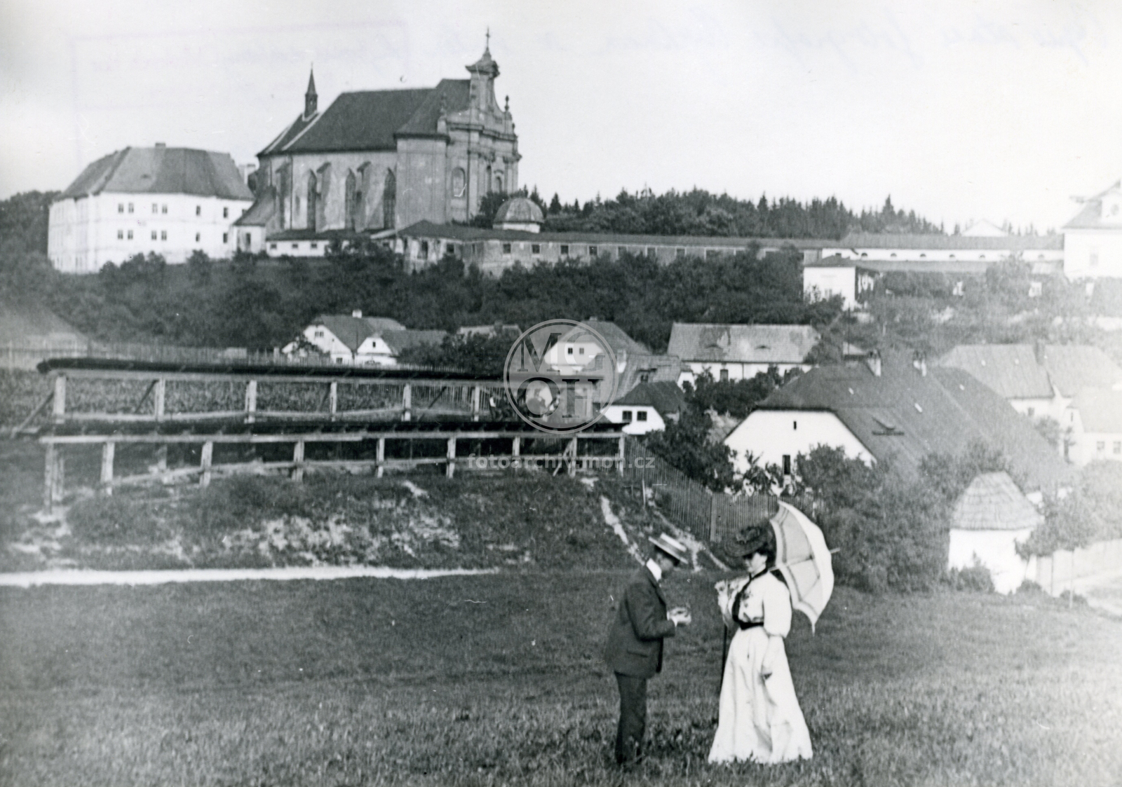 Fotografie - Pohled na kostel Nejsvětější Trojice a piaristické gymnasium, vpředu soukenické rámy