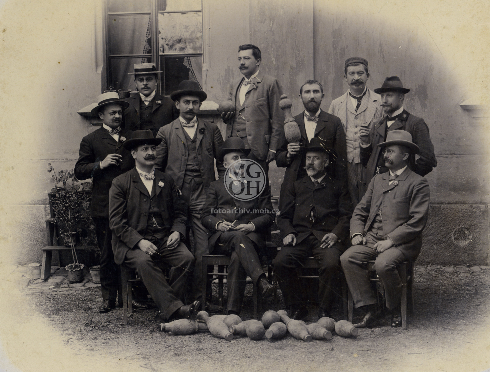 Fotografie - Kuželkáři u hotelu Procházka:
1. řada (sedící) zleva: okr. tajemník Bohuslav, notář Jeschke, poštmistr Albrecht, okr. úředník Meidl
2. řada zleva: okr. tajemník Dr. Wolf, prof. Muk, ředitel školy Koláček, lesní Hamáček
3. řada zleva: z lékár