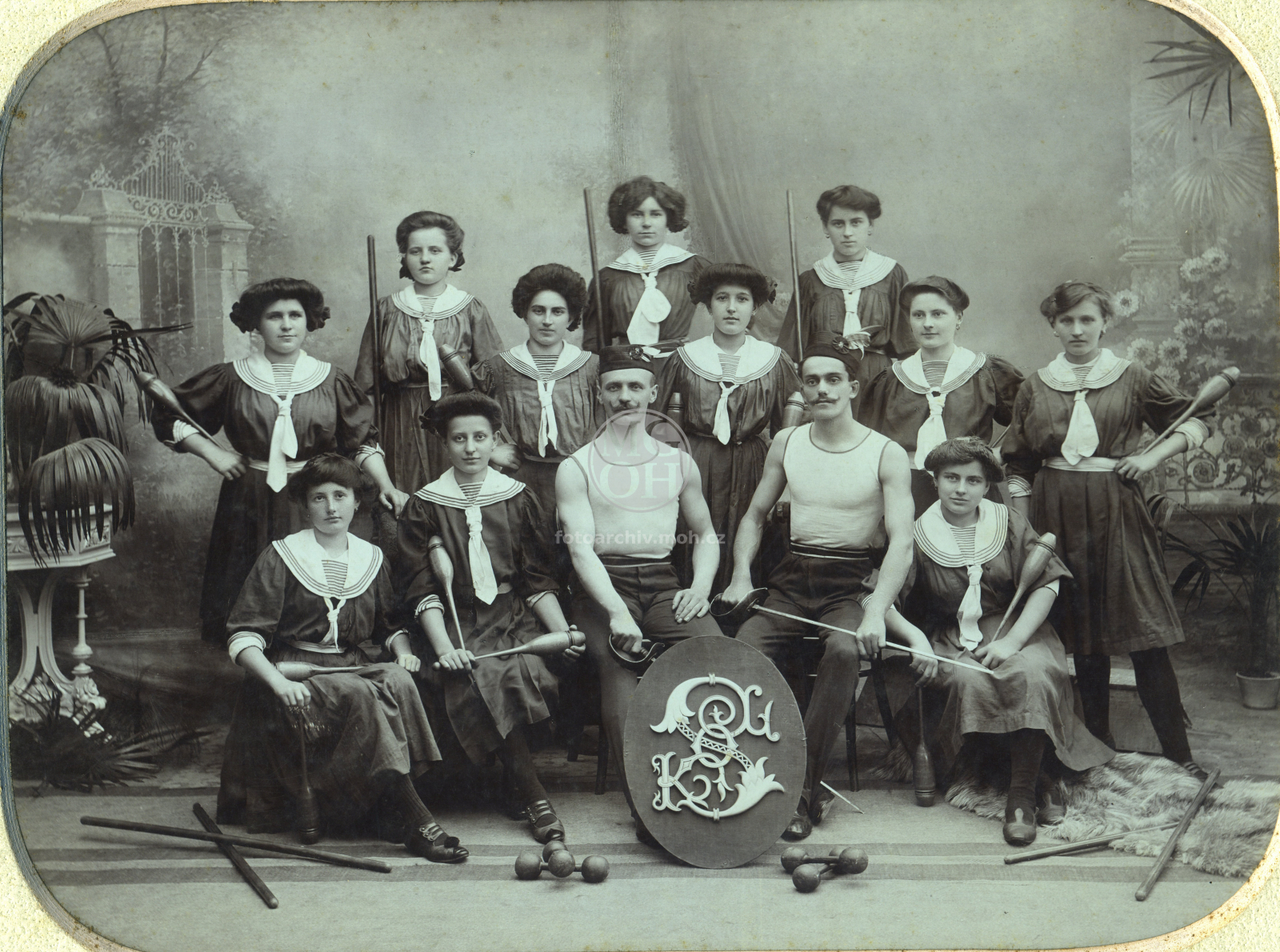 Fotografie - Skupina sokolek ve cvičebních úborech a dva sokolové, jeden z nich náčelník Sokola Hajdyš